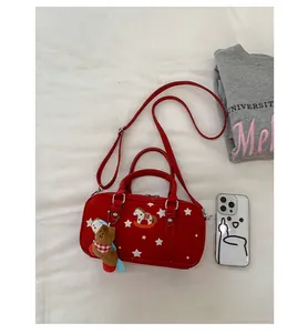 Detail of red Boston bag with star print and cute plush horse charm on white fabric