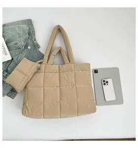 Détail d'un ensemble de sacs cabas matelassés beige avec pochette zippée assortie et accessoires