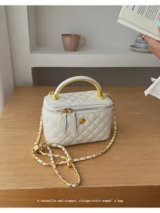 Detailed view of white quilted leather vanity bag with golden rose and chain strap
