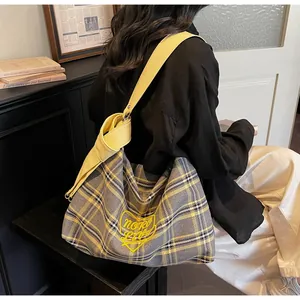Detail of grey plaid hobo bag with yellow Noro Love embroidery and wide strap