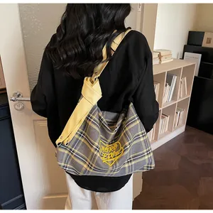 Detail of the yellow Mono Love heart embroidery on a checkered canvas tote bag