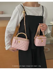 Detail showing two sizes of pink quilted leather bags with gold camellia logo and chain
