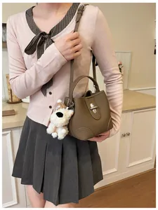 Brown bucket bag with litchi grain leather and cute plush puppy charm detail