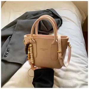 Detail der rosa PU-Leder Eimertasche mit Holzperlenanhänger und verstellbarem Goldriemen