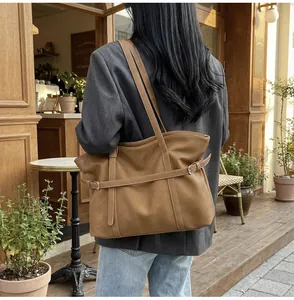 Nahaufnahme der braunen Retro-Ledertasche mit Silberschnalle und Schultergurt-Details