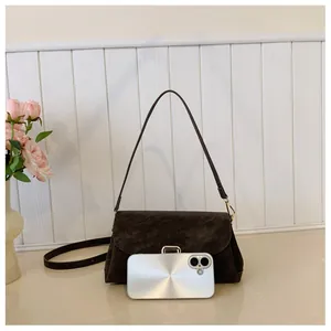 Detail view of coffee brown matte handbag with smartphone for size comparison