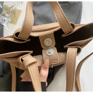 Détail de la fermeture aimantée et du cuir grainé sur le sac seau beige chic