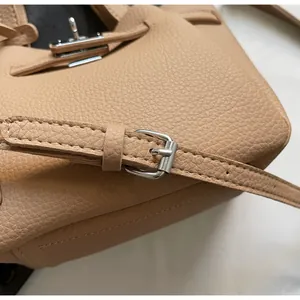 Détail d'un sac seau en cuir caramel avec grain texturé et fermoir en métal argenté