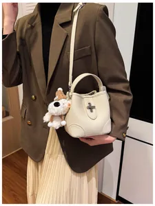 Detail of cream bucket bag in pebble leather with silver twist lock and puppy charm