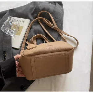 Détail d'un sac à main en cuir grainé avec poignées robustes et bandoulière réglable