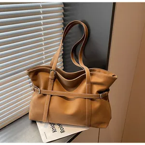 Detail der braunen Ledershopper mit feinen Nähten und dekorativer Metallschnalle