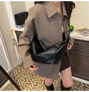 Detail of black pleated croissant bag with smooth leather texture and zipper closure