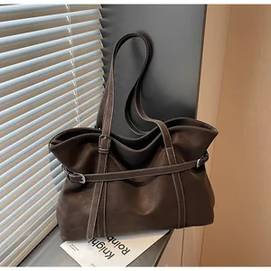 Detail der dunkelbraunen Leder-Shopper-Tasche mit weißen Kontrastnähten und Schnalle