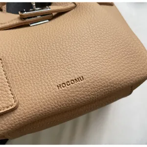 Gros plan sur la texture du cuir grainé et boucle métallique du sac seau