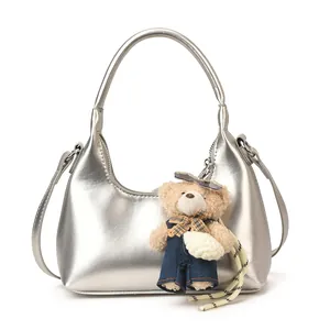 Metallic silver crescent shoulder bag with a cute plush bear pendant accessory