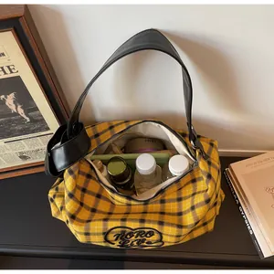 Detail view of plaid tote bag interior showing spacious capacity and heart patch