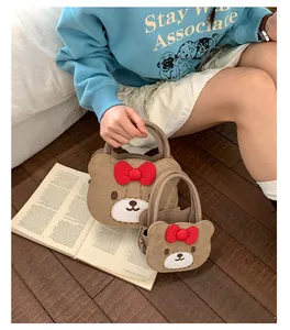 Details von zwei bärenförmigen Handtaschen aus braunem Wildleder mit roten Schleifen