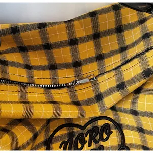 Detail of silver zipper and heart embroidery on yellow plaid tote bag with NORO patch