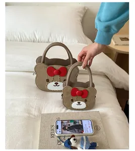 Detailansicht der braunen Bär-Taschen mit roter Schleife und Plüschtextur