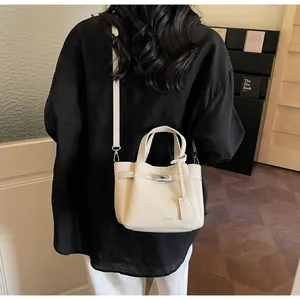 Détail du sac crème en cuir grainé avec fermoir rotatif et logo MOCOMU gravé