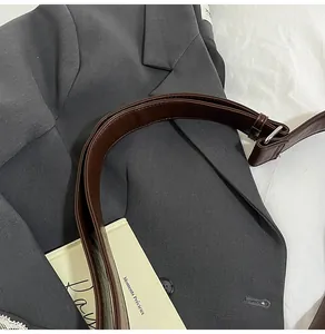Detail of dark brown leather shoulder strap with metal buckle for casual crossbody bag