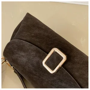 Detailed view of the dark brown textured leather and golden rectangular metal buckle