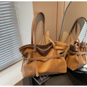 Detailansicht der braunen Ledertasche mit Schnallenriemen und Falten im Spiegelbild