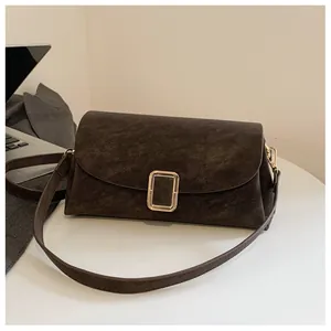 Detailed close-up of dark brown suede crossbody bag with premium gold rectangular clasp