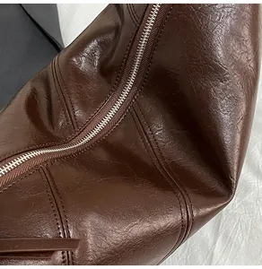 Detailed macro shot of vintage brown PU leather texture and silver zipper of the bag