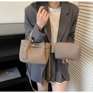 Détail de l'ensemble sac seau en cuir taupe avec bandoulière amovible et pochette