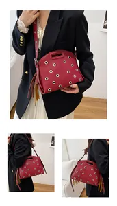 Dettaglio borsa in pelle rossa a grana litchi con borchie argentate e frange