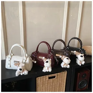 Detailansicht bunter Boston-Handtaschen aus Glänzendem Leder mit süßen Hunde-Anhängern