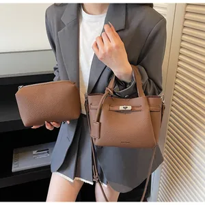 Détail d'un ensemble de sacs seau en cuir grainé marron avec fermoir rotatif métallique