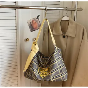 Detail of yellow and grey plaid hobo bag with Moro Love heart embroidery on coat rack