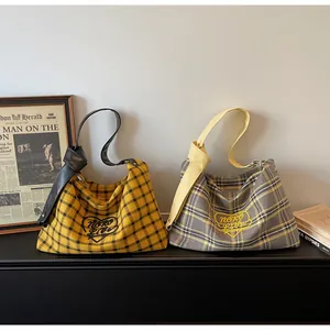 Close-up of checkered canvas shoulder bags with heart embroidery and PU leather straps