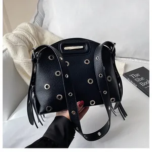Dettaglio borsa in pelle martellata nera con decorazioni di occhielli in metallo argento