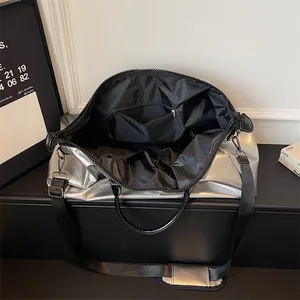 Grand sac de voyage argenté métallisé avec bandoulière noire réglable et confortable