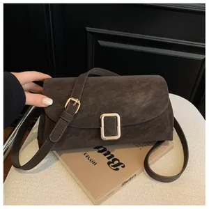 Close-up of deep brown vintage square bag with matte leather texture and gold hardware