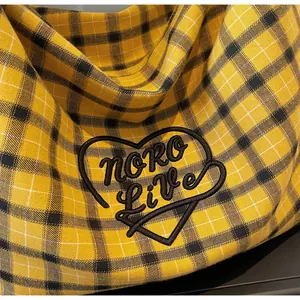 Detail of yellow checkered tote bag featuring heart embroidery and fine canvas texture