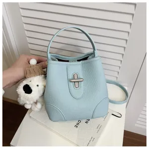 Close-up of light blue bucket bag showing lychee grain texture and silver swivel lock