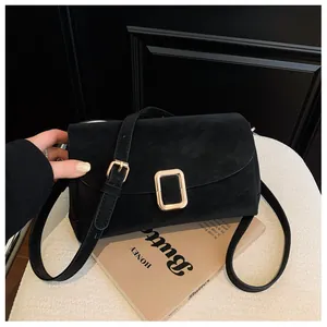 Close-up of black suede crossbody bag featuring a premium gold square metal buckle clasp