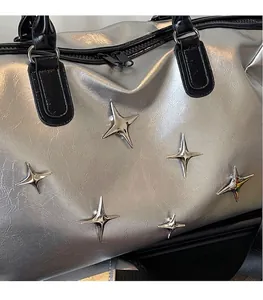 Détails de sac argenté texturé avec clous en étoile métalliques et accents de noir