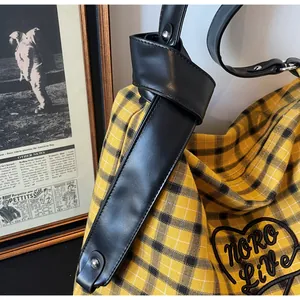 Detail of yellow and black checkered tote bag featuring Noro Live letter embroidery