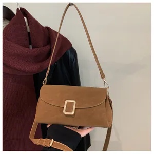 Detail view of tan rectangular crossbody bag with gold buckle and matte finish texture