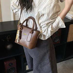 Vintage braune PU-Leder Beuteltasche mit Holzperlen Anhänger und goldenem Logo-Schriftzug