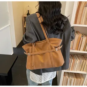 Detailansicht einer braunen Vintage-Tasche mit Metallschnallen in einem gemütlichen Zimmer