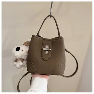 Detail of lychee pattern leather bucket bag with silver twist lock and puppy charm