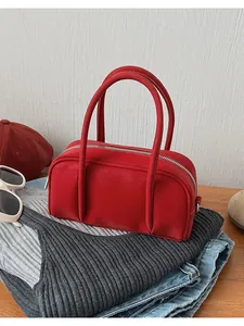 Dettaglio della borsa squadrata rossa sui vestiti con cerniera e pelle liscia