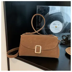 Detailed view of vintage brown square bag featuring a prominent gold rectangular clasp