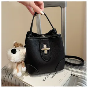 Detail of black lychee grain leather bucket bag with silver metal twist lock and handle